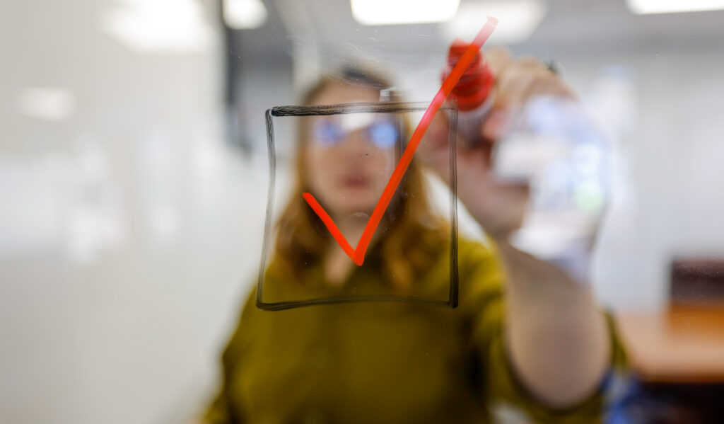 A project manager checks a box representing another short-term win.