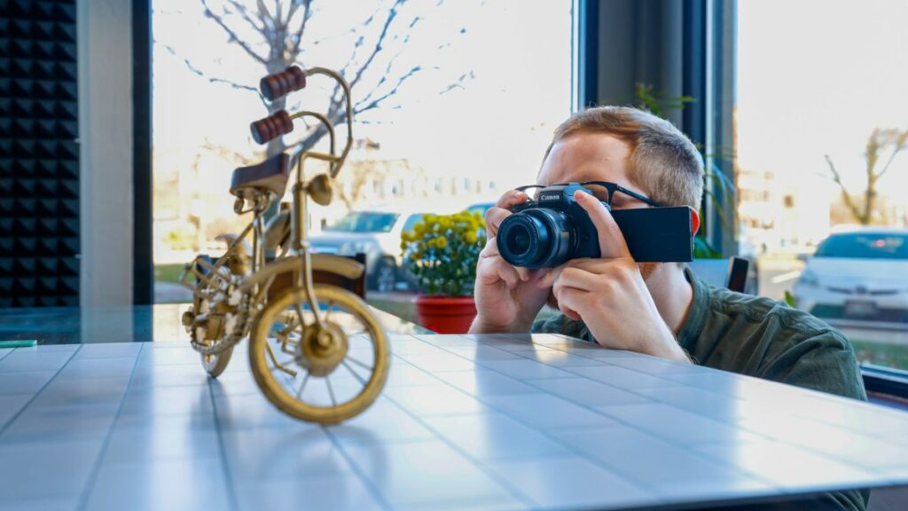 Joel of Viral Solutions taking a photograph of a bicycle figurine to demonstrate the importance of product images.