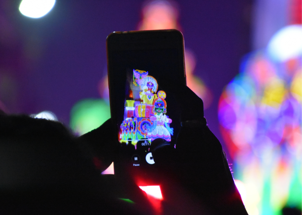  hands holding up mobile device recording colorful event for Instagram Stories