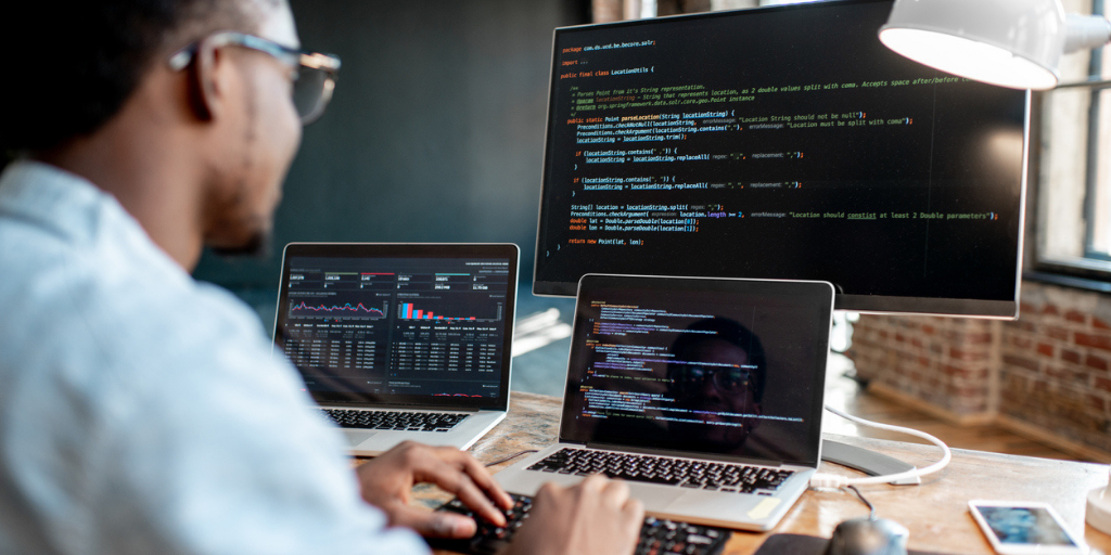 A male website developer working with different programs in an office.