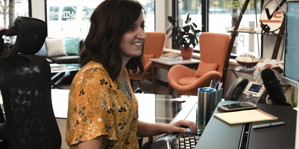 Lindsey of Viral Solutions sitting at desk in front of computer. 
