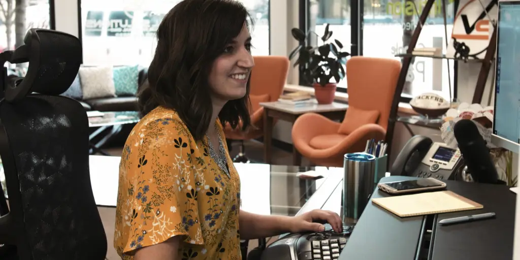 Lindsey of Viral Solutions sitting at desk in front of computer.