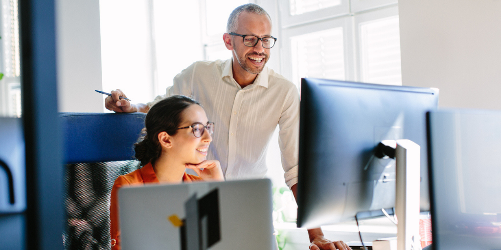 Businessman speaking with a company computer programmer for his business website.