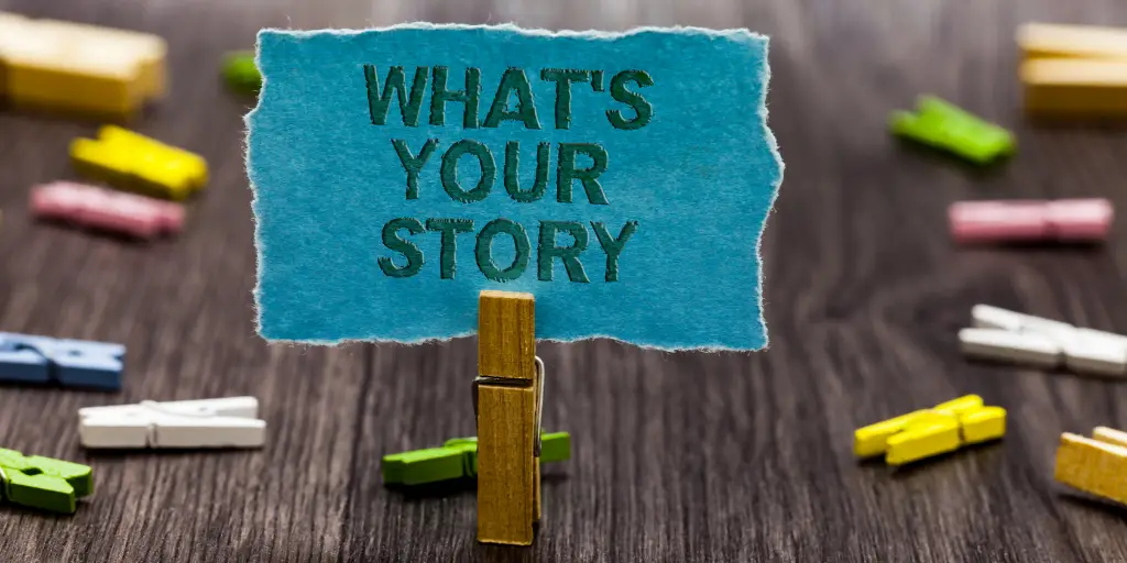Piece of paper that says "what's your story" standing up in a clip.