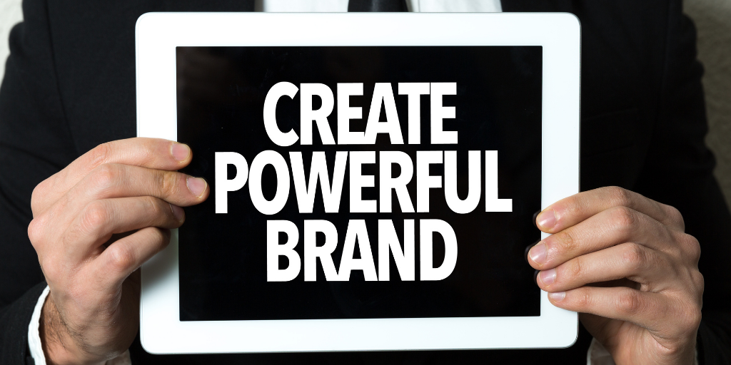 Man in suit holding sign that says ‘Create Powerful Brand’ highlighting the importance of brand salience.