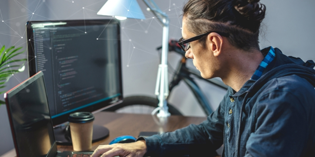 Male IT specialist working in an office and using computers for site migration process.