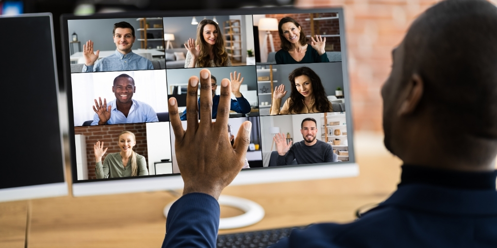 Man using basic hand signals during an online video conference with team members.