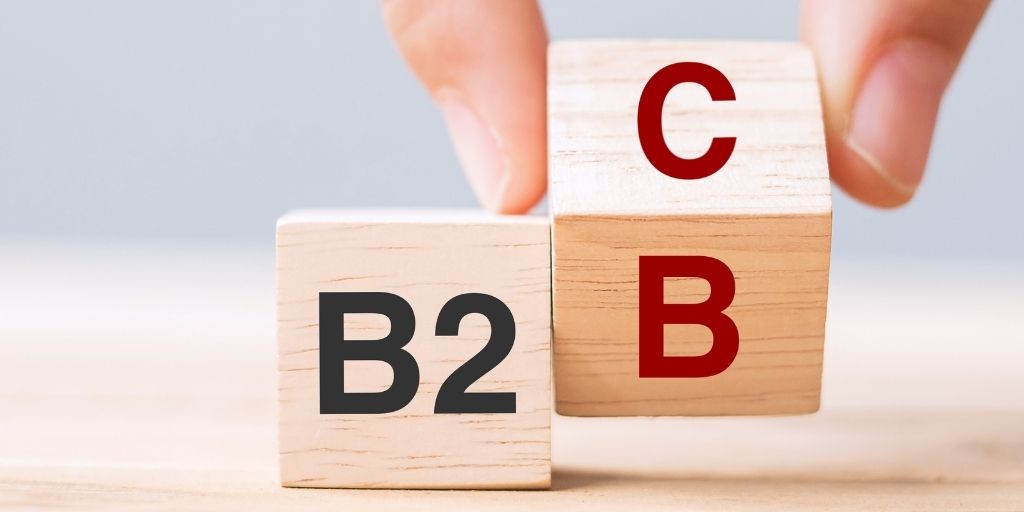 Hand turning over wooden letter blocks from B2C to B2B.