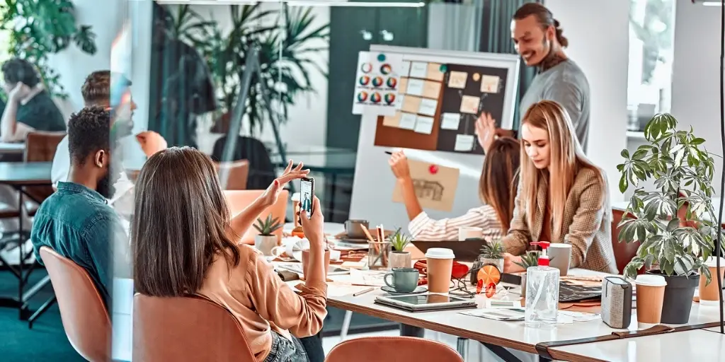 Couple shopping and buying gifts for the holidays, looking at a mobile phone showing holiday promotions.