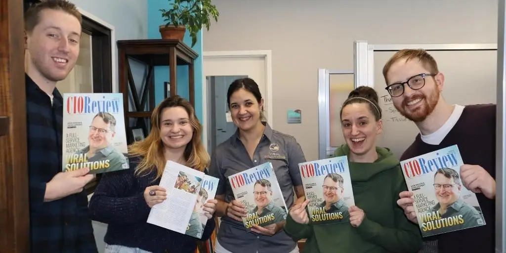Viral Solutions Main Office team celebrating their win while holding up CIOReview magazine.