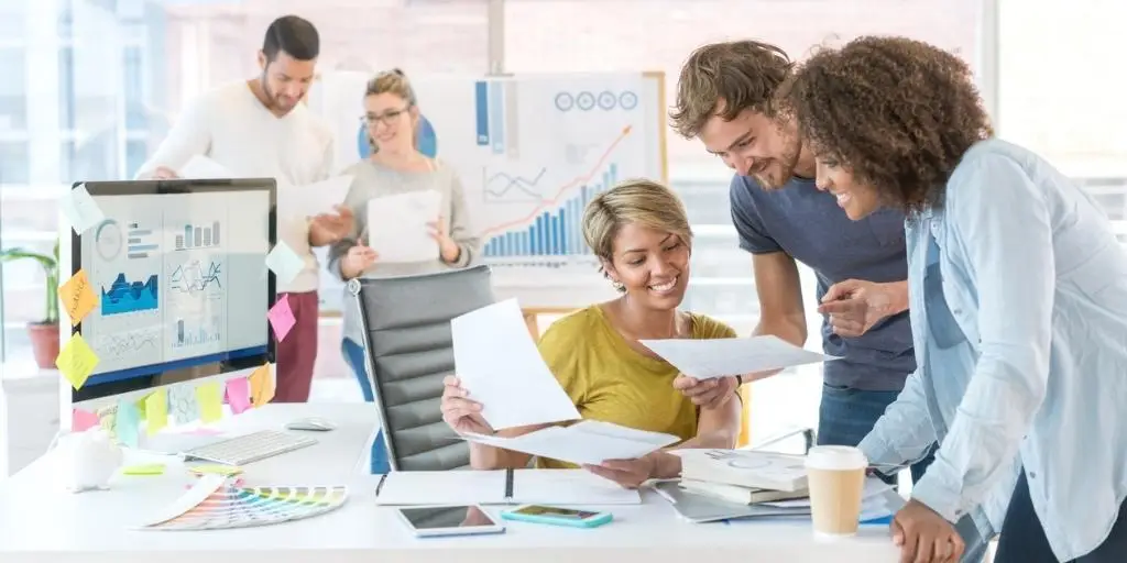 Sales and marketing team in an office assessing their company's metrics for their ABM campaigns.