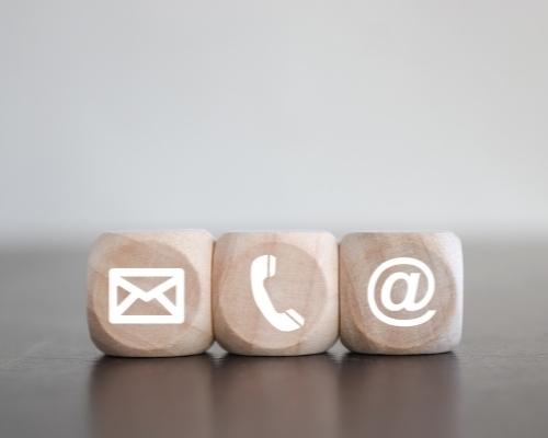 Three wooden dice with communication type icons symbolizing modes of communication for direct response marketing.