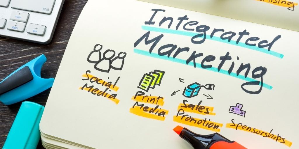 "Integrated Marketing" written with marker in notebook.
