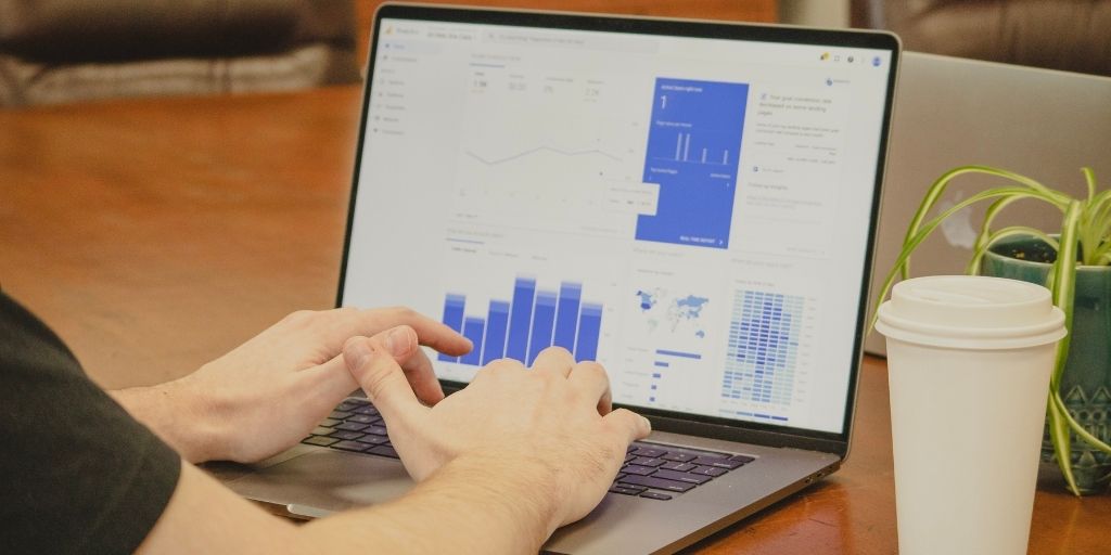 A Team member using his laptop to look at social media data collected from consumers.