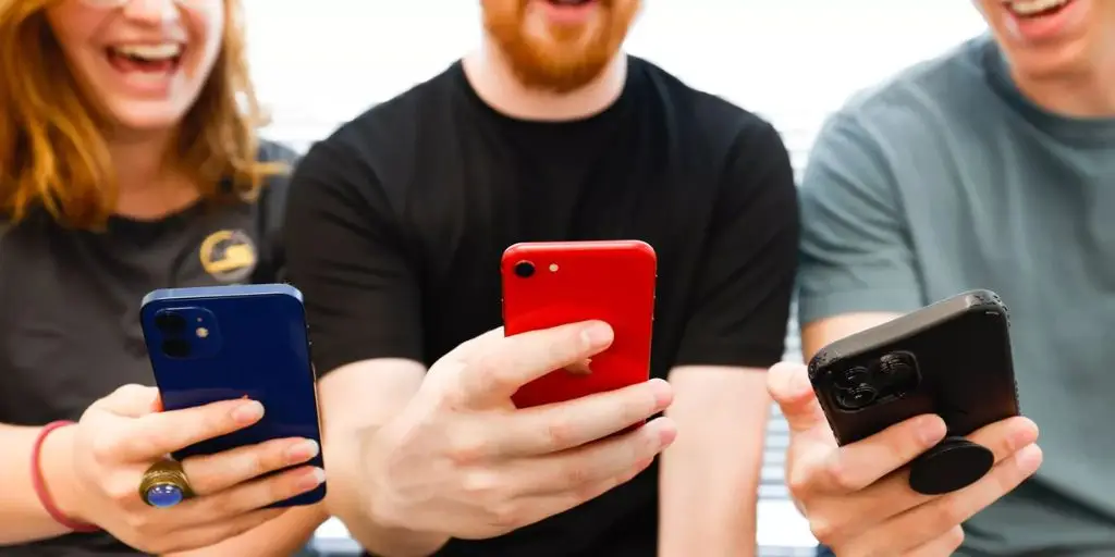 Group of consumers using mobile phones to access social media applications