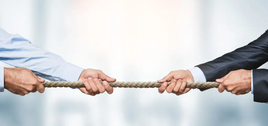 Two businessmen playing tug-of-war as a concept for business competitors