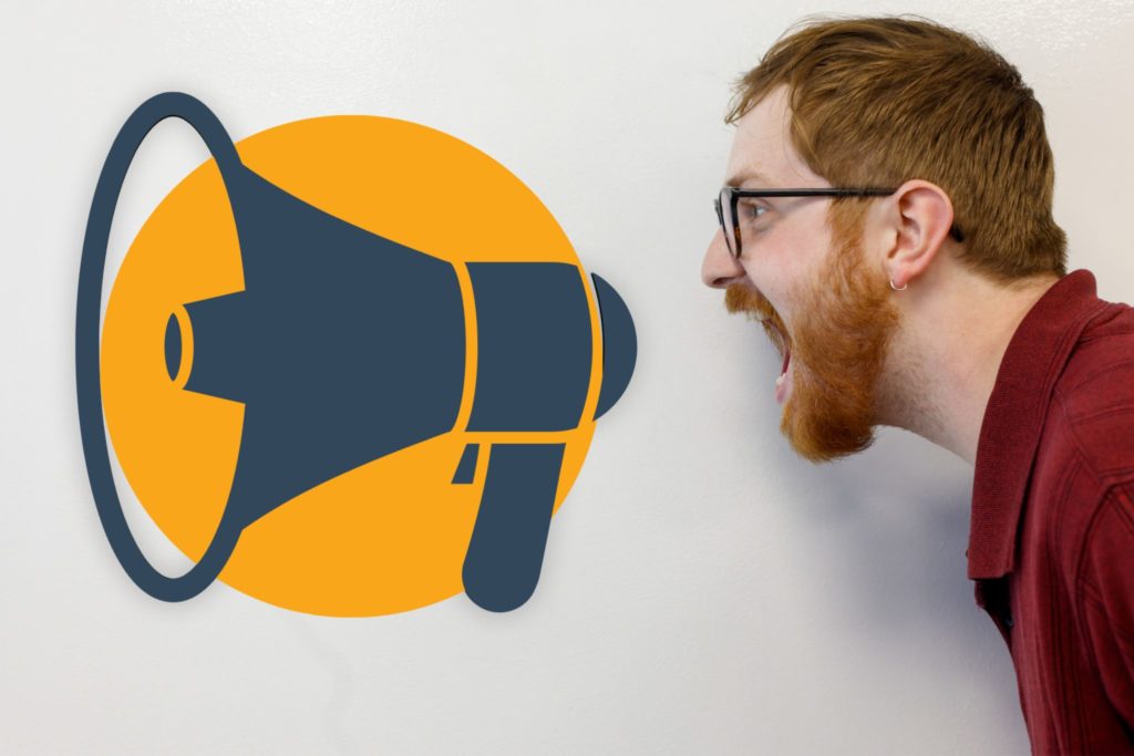 Joel of Viral Solutions yelling into a megaphone graphic on a whiteboard as concept for developing a brand voice.