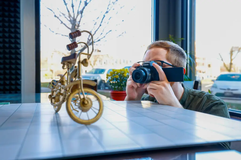 Photographer taking pictures of his products to put on his site- a core concept in how to increase online sales.
