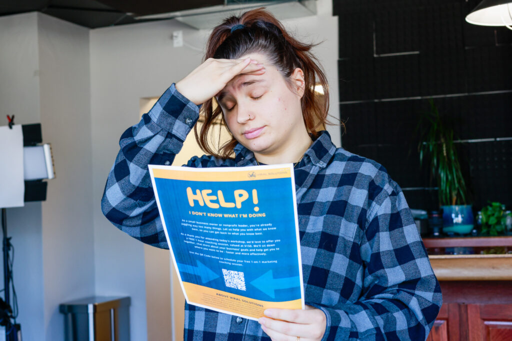 Holland of Viral Solutions looking stressed and holding a piece of paper that says help.