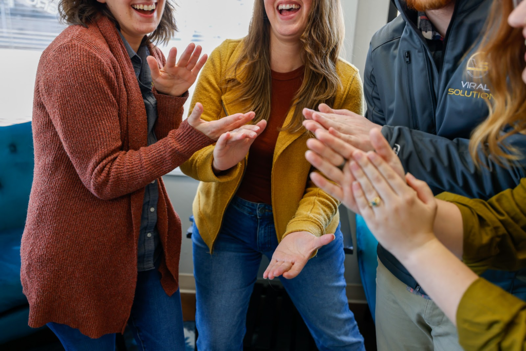 A group of marketers clapping and smiling after a successful project.